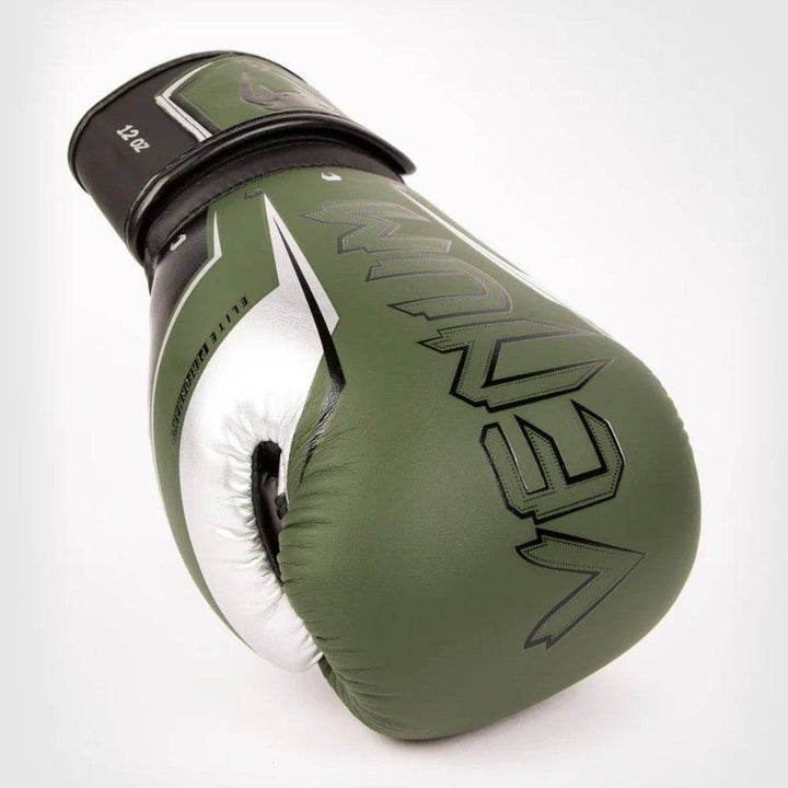 Angled khaki-silver glove lying on side showing full silver “VENUM” print.