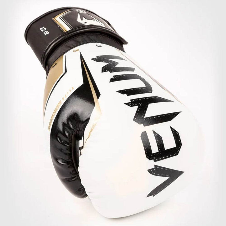 Single white-gold glove resting on knuckles to display curvature and gold graphics.
