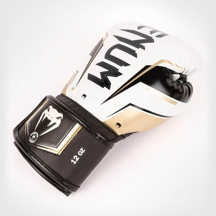 Front angled view of the White gold venum elite evo gloves with bold black venum logo on the knuckle area.