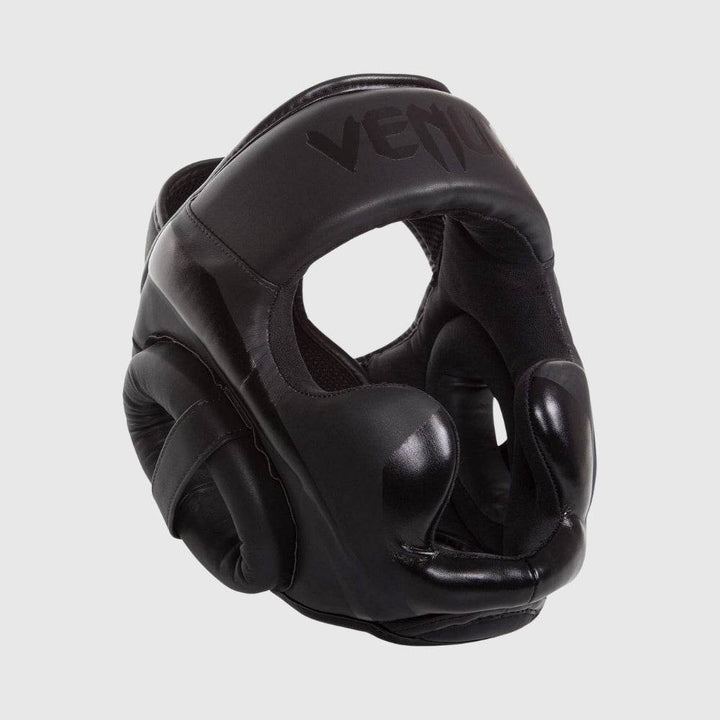 Angled view of the black Venum Elite headgear with full-face padding and matte black logo.