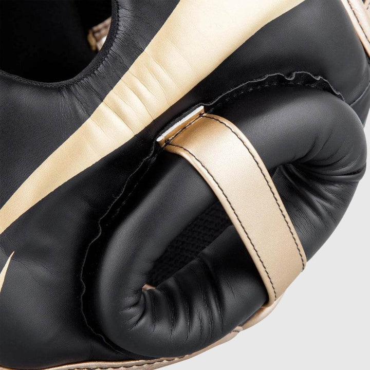 Macro view of the ear padding structure, showing reinforced stitching and a gold strap accent around the ear opening.