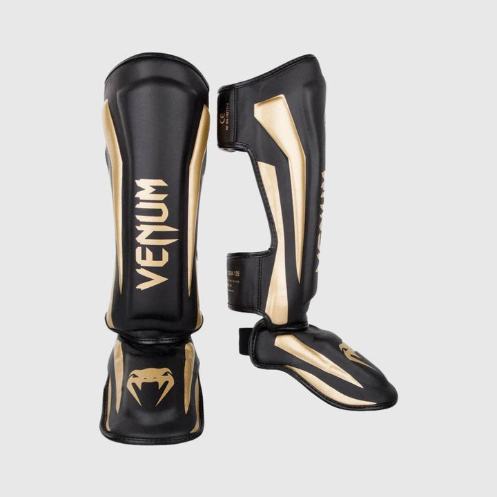 Venum elite stand up shinguard image showing side and front views of black and gold shin guards.