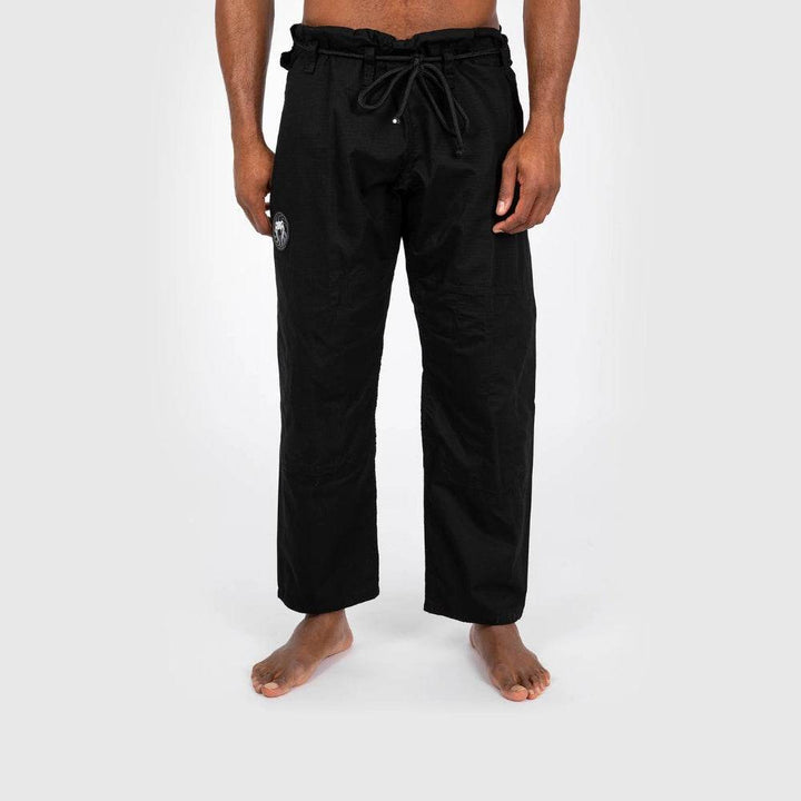 Front view of the gi pants only, showing waistband drawstrings and the Venum logo on the upper thigh.