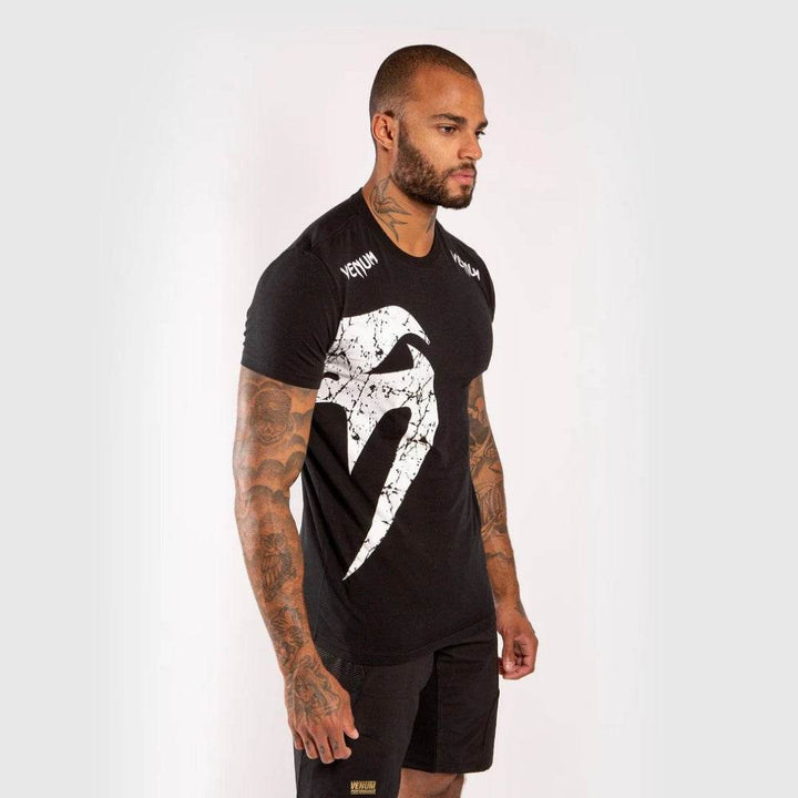 Black Venum t-shirt with bold Venum snake logo print extending across the front and right shoulder.