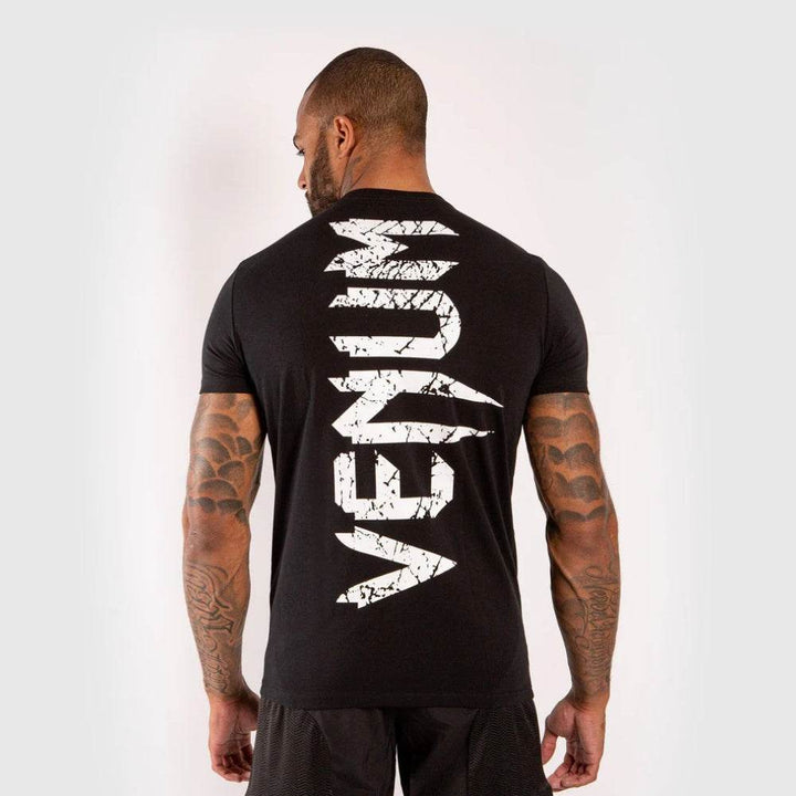 VENUM printed vertically down the back in distressed white font on black t-shirt.
