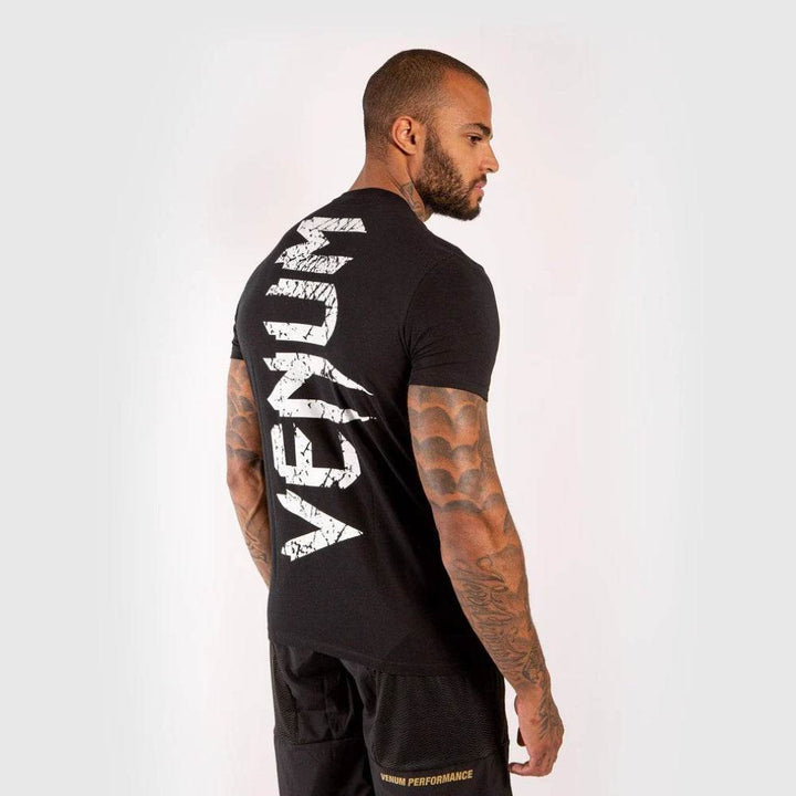 Man modeling the Venum tee showing vertical Venum text logo on the back.