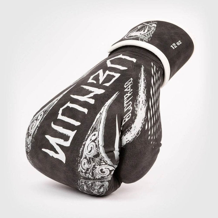 Opposite-side view of glove on knuckles, featuring jagged white “VENUM” wordmark and intricate scrollwork on thumb.