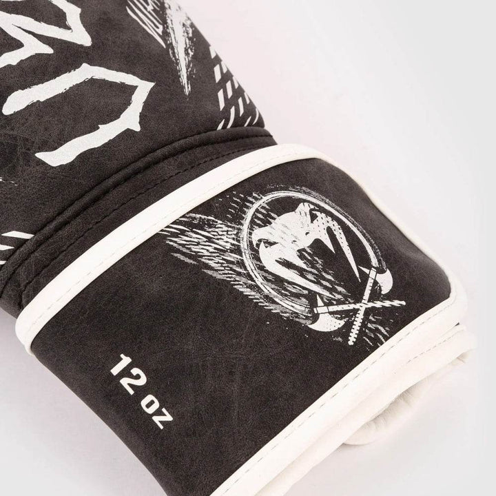 Close-up of black suede-finish wrist strap with white trim, 12-oz weight print and crossed-axe Venum badge.