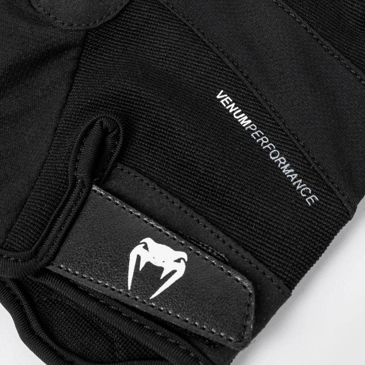 Macro close-up of the Velcro wrist strap on the Venum Performance glove, clearly showing the Venum snakehead logo and reinforced stitching.