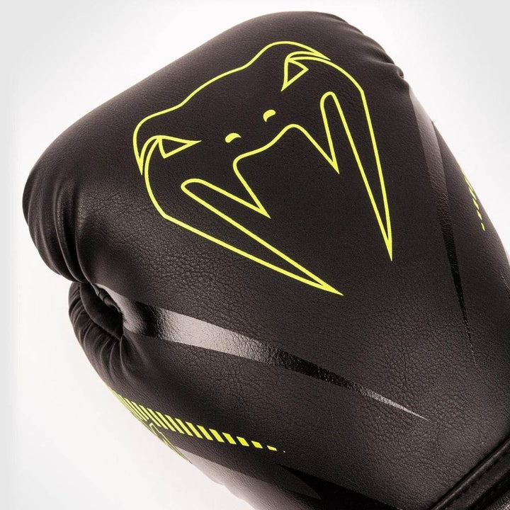 Close-up of the glove’s knuckle area, displaying the prominent neon yellow Venum snakehead logo on the black leather surface.