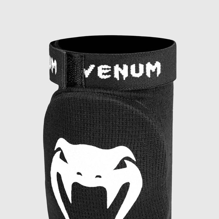 Close-up of the upper elastic band with bold white Venum branding and reinforced stitching for secure placement.
