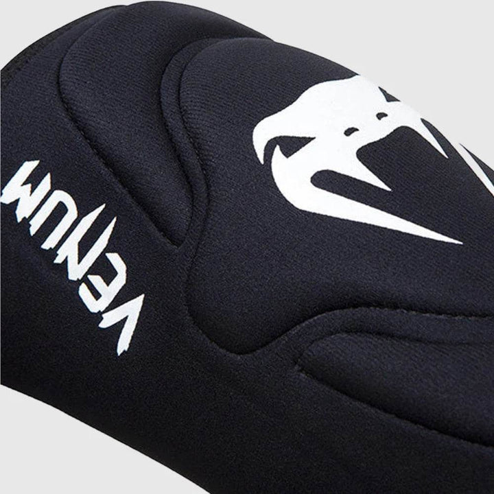 Angled shot emphasizing the contoured padding and prominent white Venum logo across the front of the knee pad.