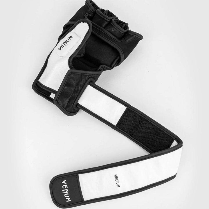 The glove lying open with its extended wrist strap fully unrolled, showing the underside of the strap and the bold white "VENUM" branding with "MEDIUM" size label.