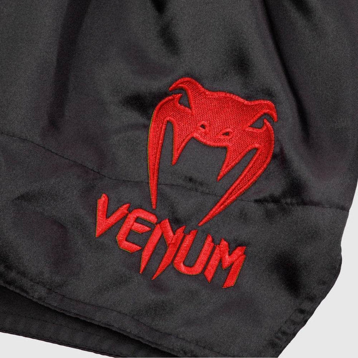 Red Venum snakehead logo and text embroidered on front left leg.