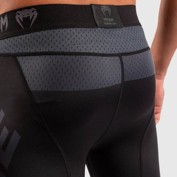 Detailed view of rear waistband and mesh ventilation panel at upper glutes, featuring Venum logo tag at center.
