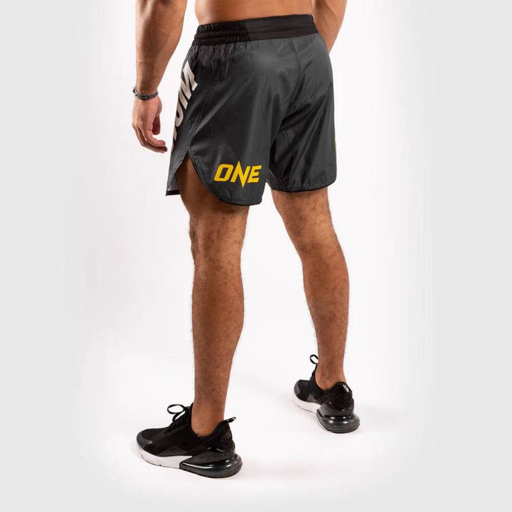 A partial back view emphasizing the leg split and yellow “ONE” logo on the right side.