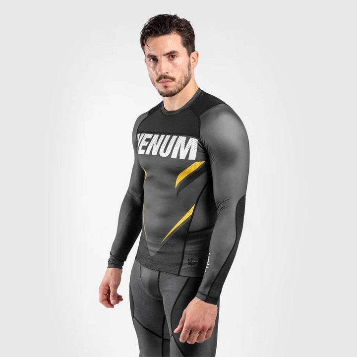 Model posed slightly sideways showing the VENUM text and curved yellow accents along the torso.