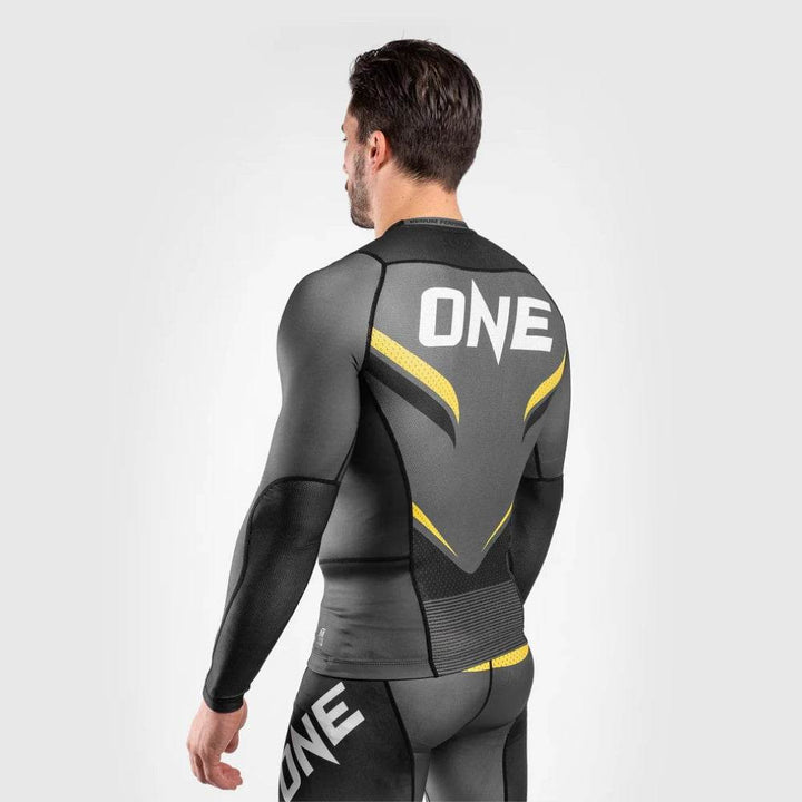 Model’s back in angled stance showing ONE logo and yellow patterns forming a V-shape.