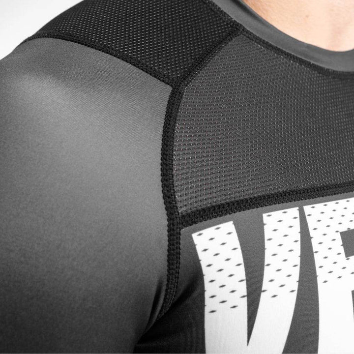 Close-up of the shoulder mesh panel stitching and texture of the rash guard material.