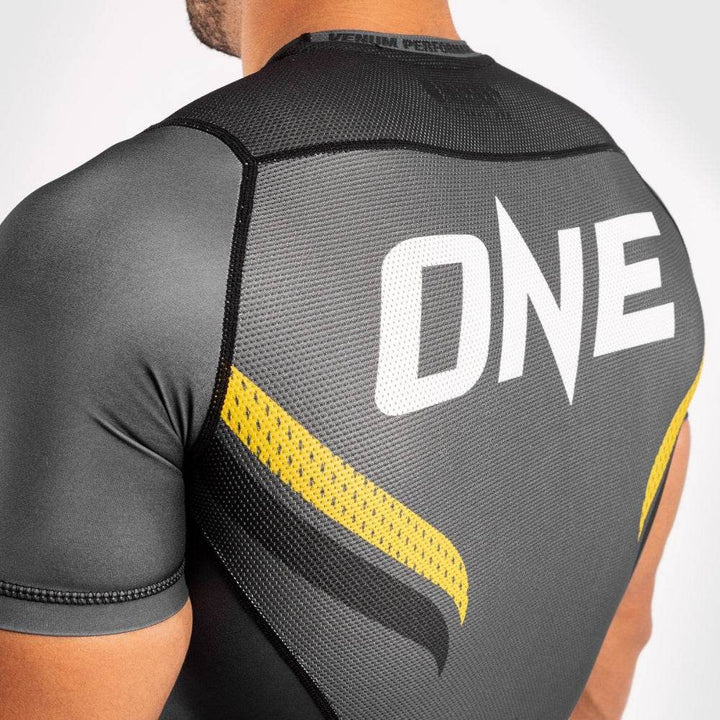 Close-up of mesh panel and “ONE” logo on upper back of the rash guard.