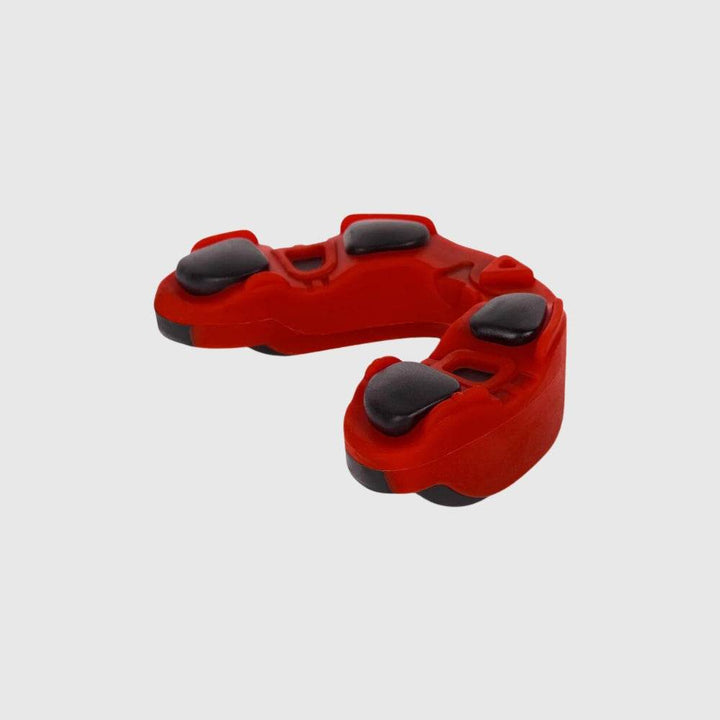 Bottom view of red variant Venum Predator mouthguard, highlighting its internal shock absorption system with black gel inserts.
