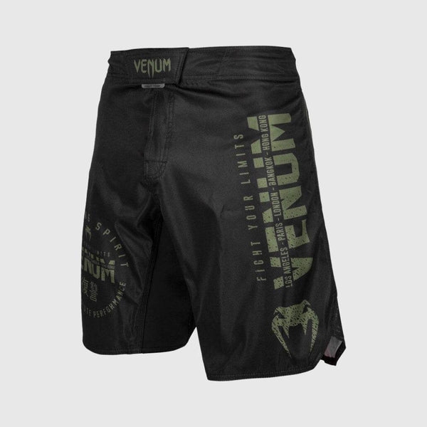 Venum long-length black fight shorts with green "VENUM" branding and typography on left leg.