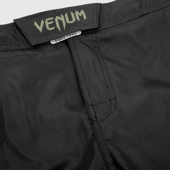 Close-up of velcro and flap waistband with green Venum logo.