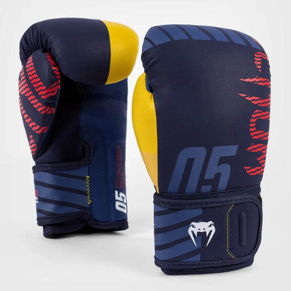 A pair of Venum Sport 05 boxing gloves in navy blue with yellow thumbs and red graphic details, standing upright with the front and rear views visible.