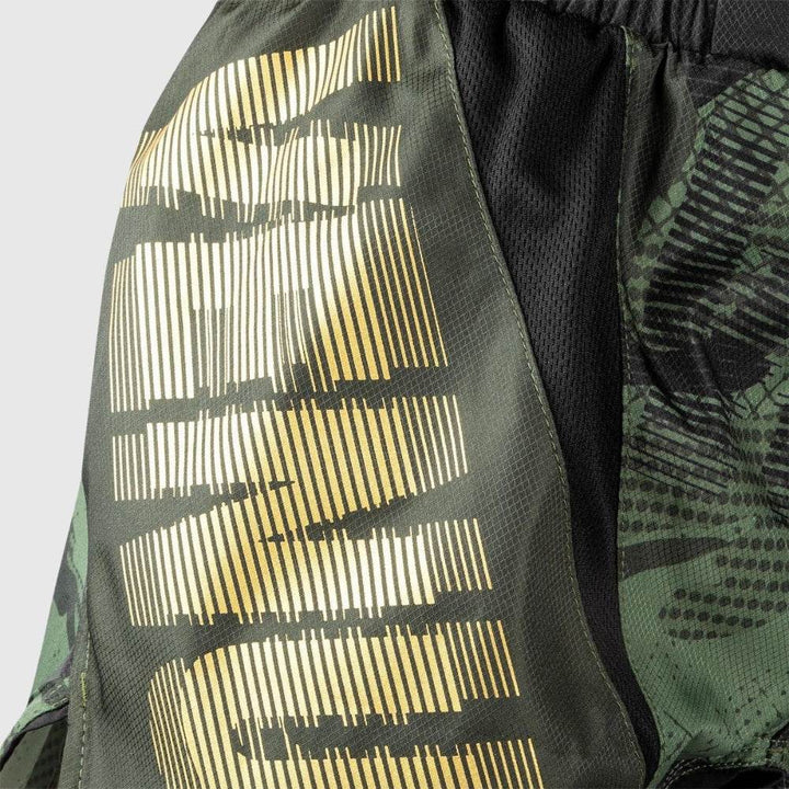 Close-up of golden Venum text detail over camouflage print on left leg.