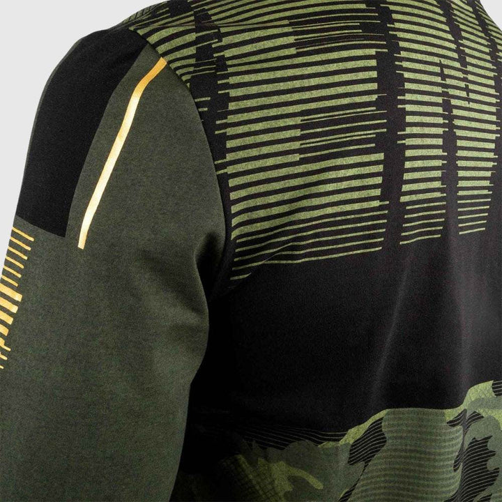 Close-up of the back shoulder area showing green and black camo print with linear yellow detailing on the sleeve.