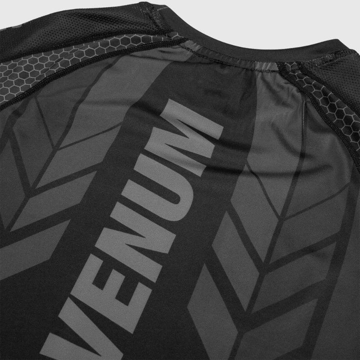 A tight crop of the rear collar area showing VENUM logo and chevron-style green print details along the back shoulder section.