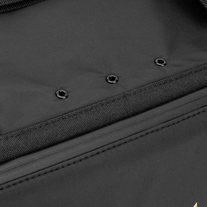 Close-up of the Venum Trainer Lite EVO Sport Bag’s base showing multiple metal grommet ventilation holes for airflow and moisture control.
