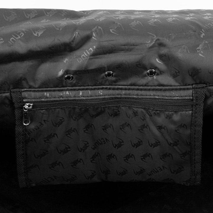 Detailed view of the Venum Trainer Lite EVO Sport Bag’s interior, featuring a zippered mesh pocket and triple ventilation eyelets, with custom Venum logo lining.