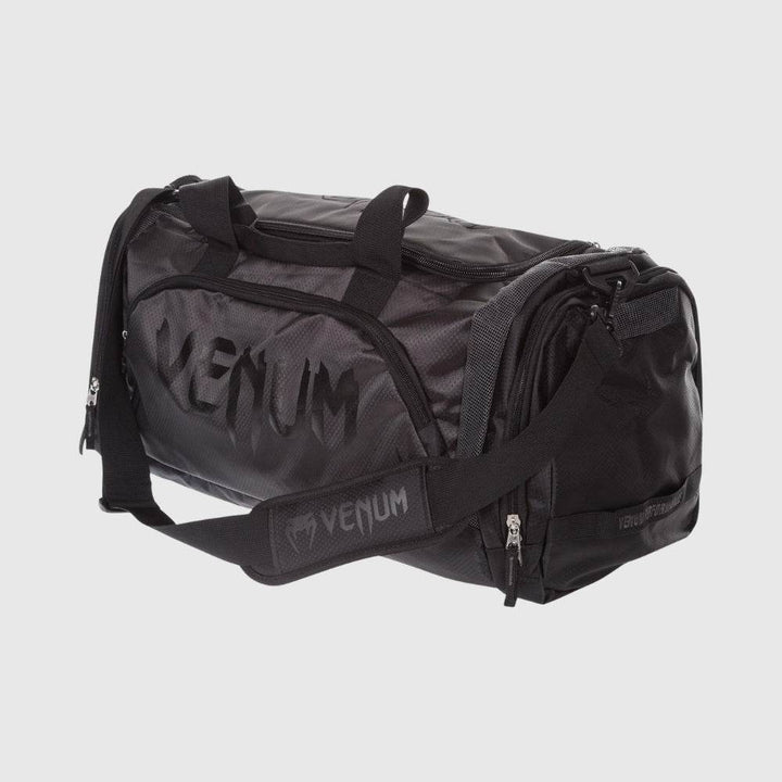 Black Venum Trainer Lite Sport Bag with white Venum logo, mesh side panel, and dual carry handles.