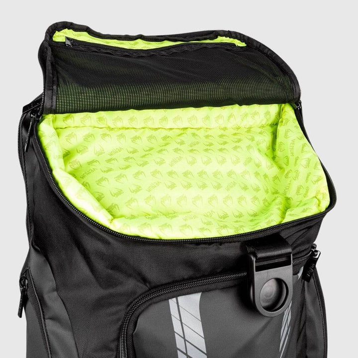 Top-down view of the Venum backpack’s spacious main compartment with neon green interior lining printed with Venum logos and a zippered mesh pocket inside the lid.