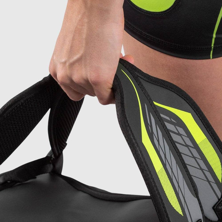 Close-up of a person’s hand gripping the Venum backpack’s padded shoulder strap with neon and reflective detailing.