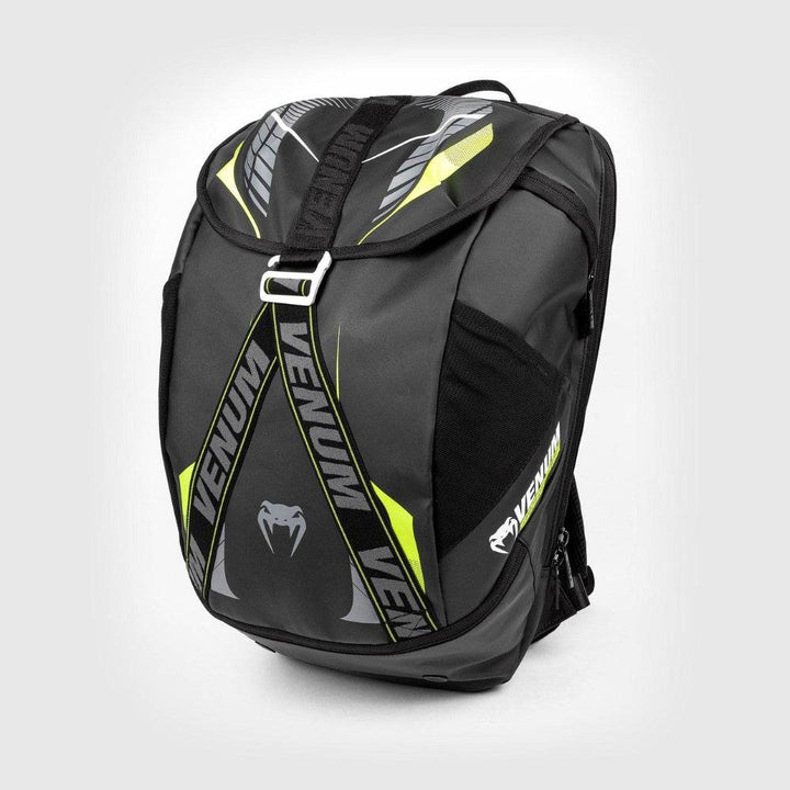 Black Venum sports backpack with neon yellow accents and bold VENUM branding, featuring a top flap with adjustable strap, side mesh pockets, and a sleek, angular design.