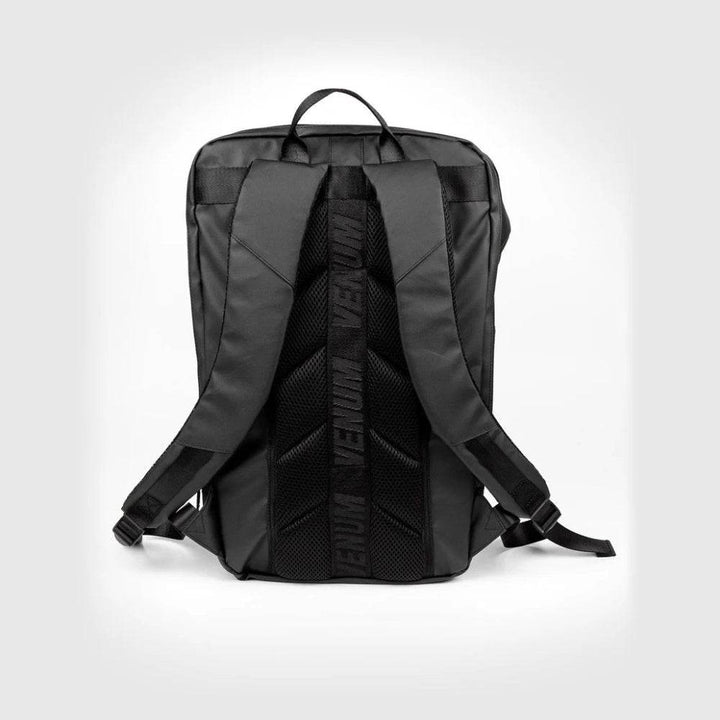 Back view of the Venum sports backpack featuring padded shoulder straps, breathable mesh back panel, and vertically printed VENUM logo on the spine for added style and comfort.
