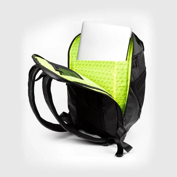 Interior view of the Venum backpack showcasing bright neon green lining with Venum logos and a zippered mesh pocket for organized storage.