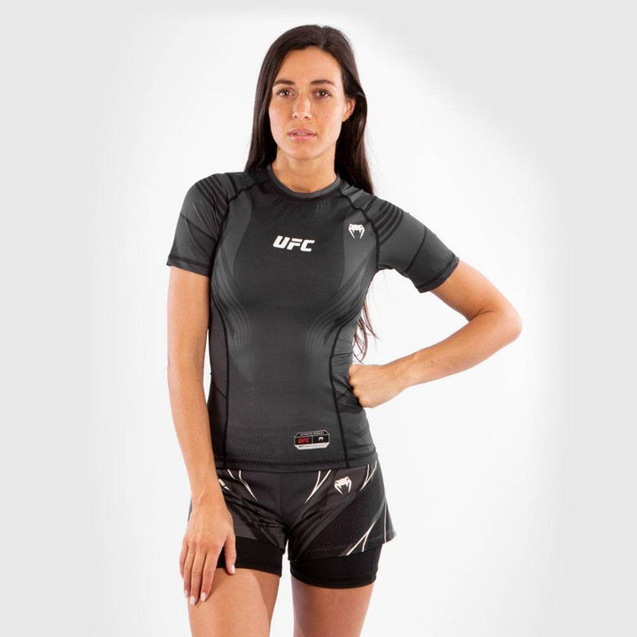 Front view of woman wearing black UFC Venum compression rash guard and shorts.