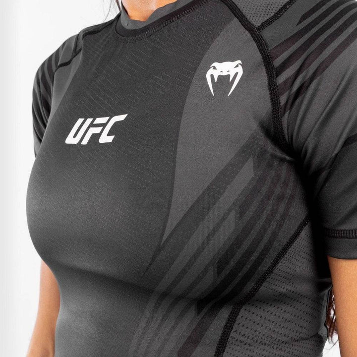 Close-up of Venum snake and UFC logos on chest of compression rash guard.