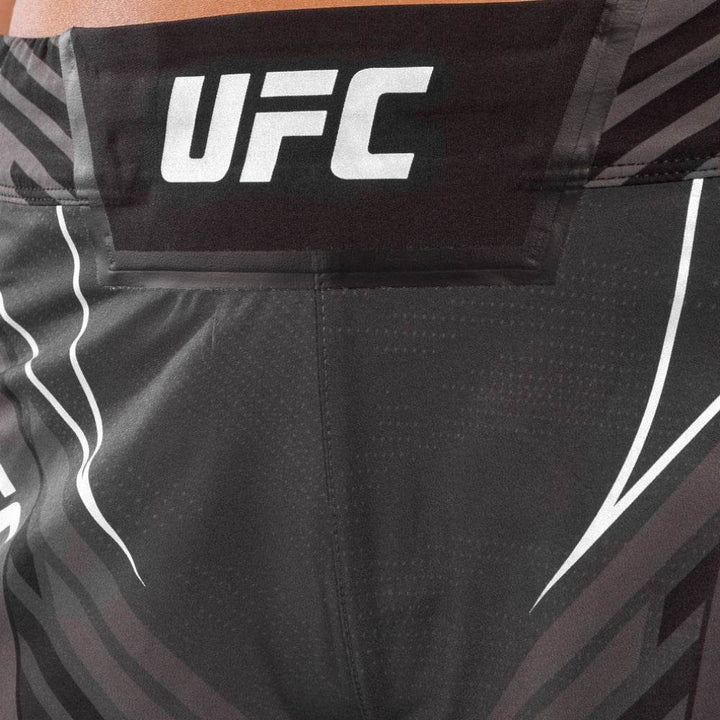 Close-up of the front waistband showing the UFC logo printed on a reinforced waistband panel.