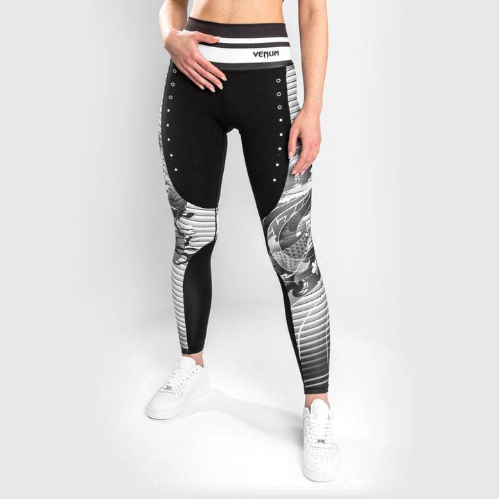 Frontal view of the leggings showing a bold dragon and stripe design, with white waistband branding.